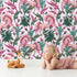Lovely child standing in front of Whimsy Tots Enchanted Meadow Prance Wallpaper in Blush Pink with unicorn, flower, tulip, leaf in design.