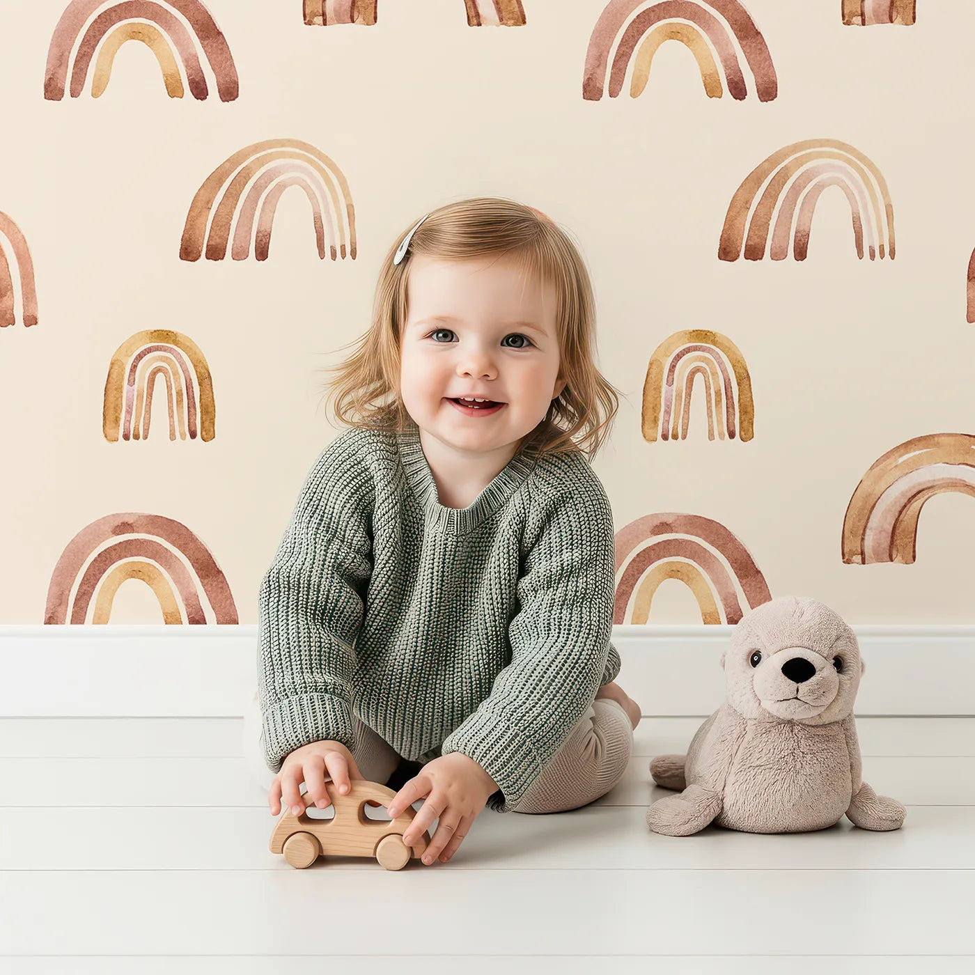 Lovely child standing in front of Whimsy Tots Boho Brush Rainbow Wallpaper in Beige with rainbow, stripe, arch in design.