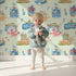Lovely child standing in front of Whimsy Tots Undersea Island Adventure Wallpaper in Mint Green with whale, turtle, dolphin, octopus, fish, starfish, shrimp, submarine, bottle, island in design.