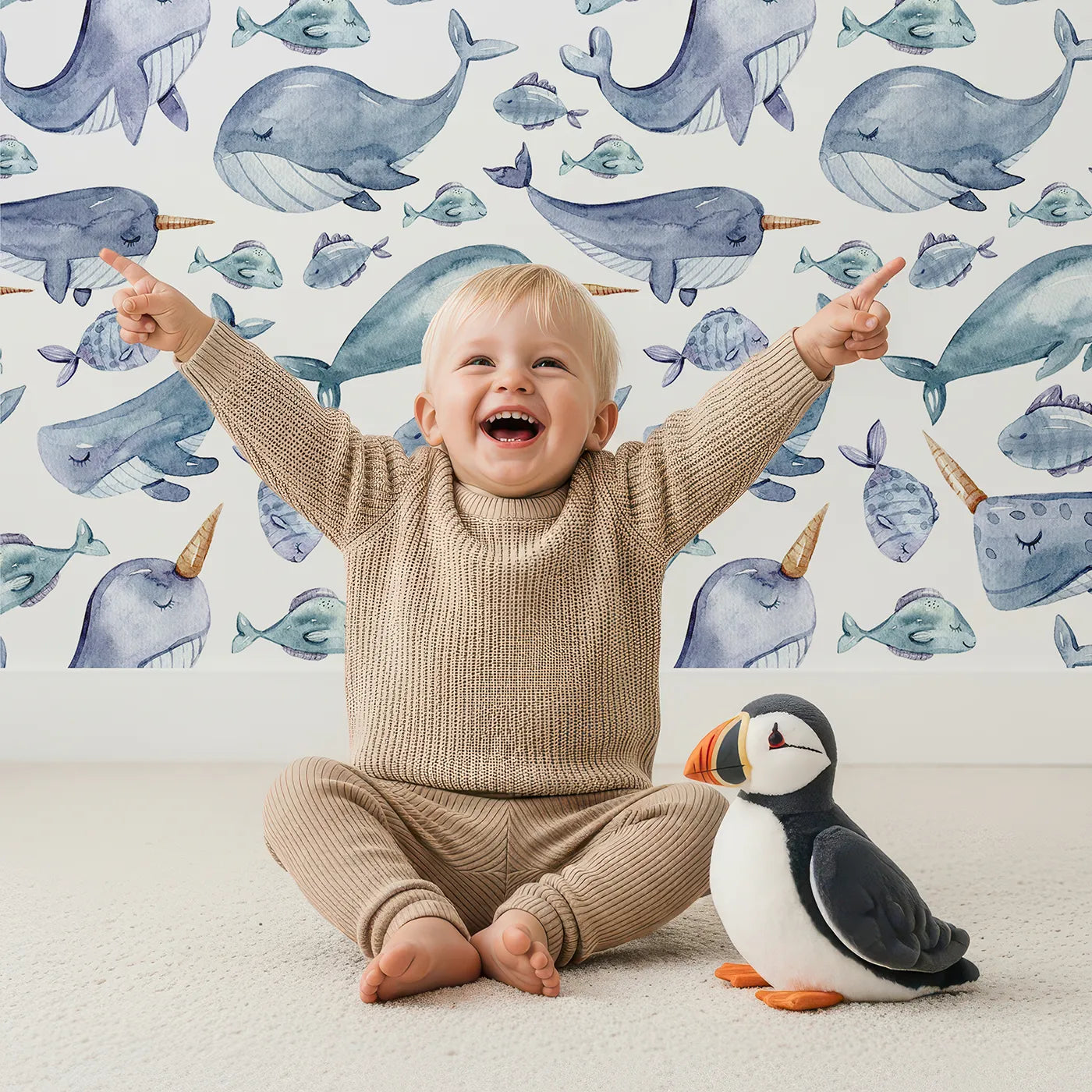 Lovely child standing in front of Whimsy Tots Sleepy Sea Friends Wallpaper in White with whale, narwhal, fish in design.