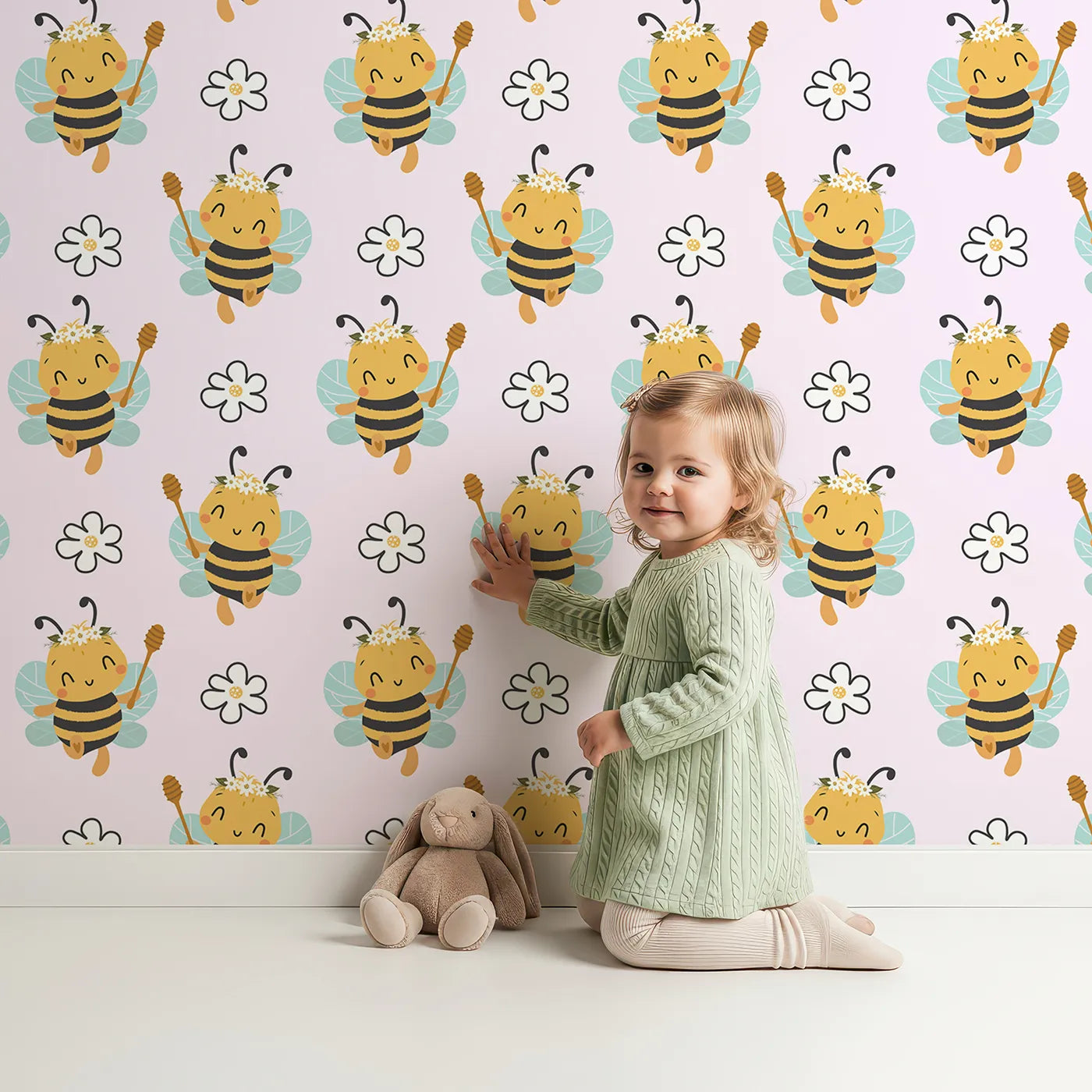 Lovely child standing in front of Whimsy Tots Bee Blossom Parade Wallpaper in Blush Pink with bee, flower, honey in design.
