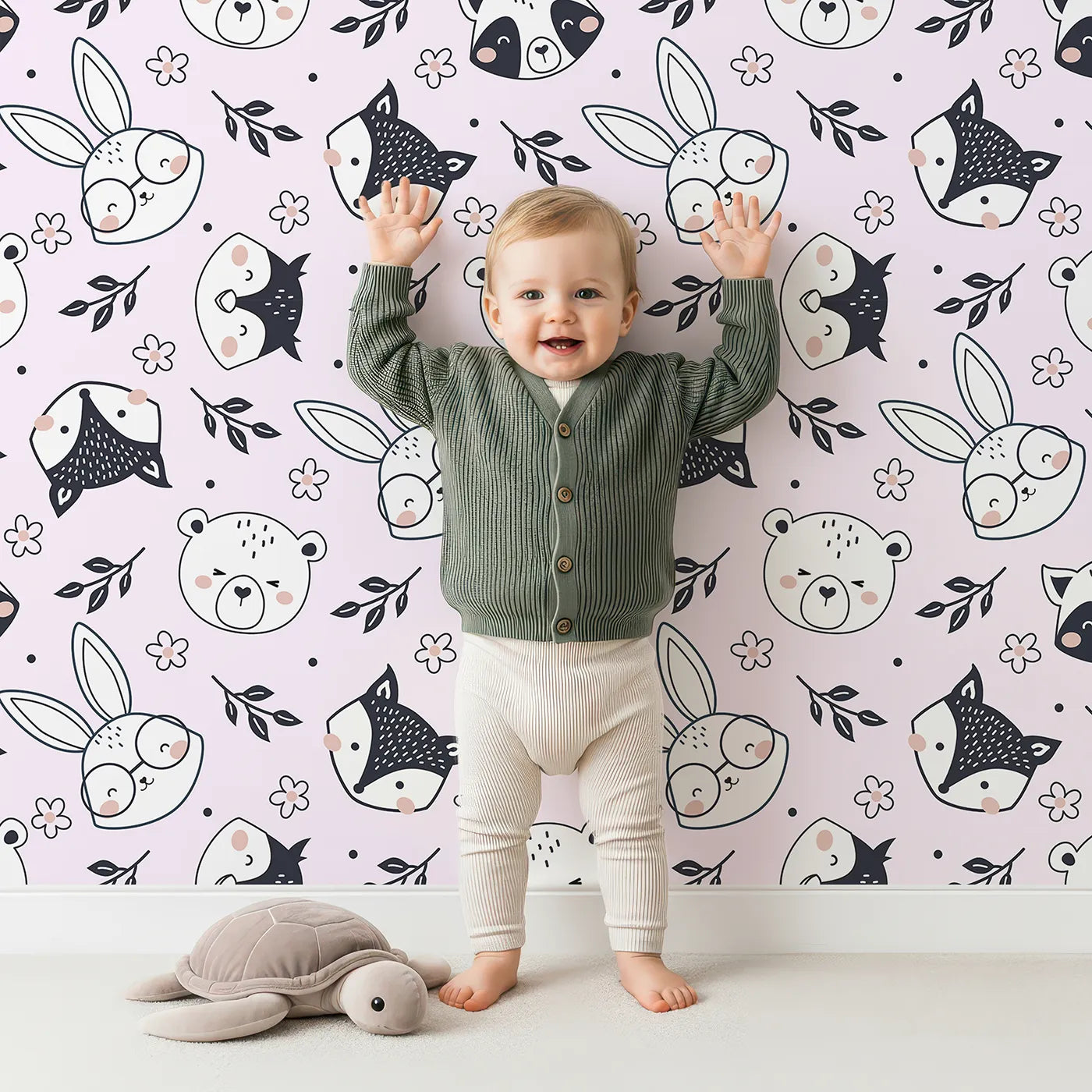 Lovely child standing in front of Whimsy Tots Woodland Scribble Friends Wallpaper in Blush Pink with bear, bunny, fox, raccoon, flower, leaf in design.