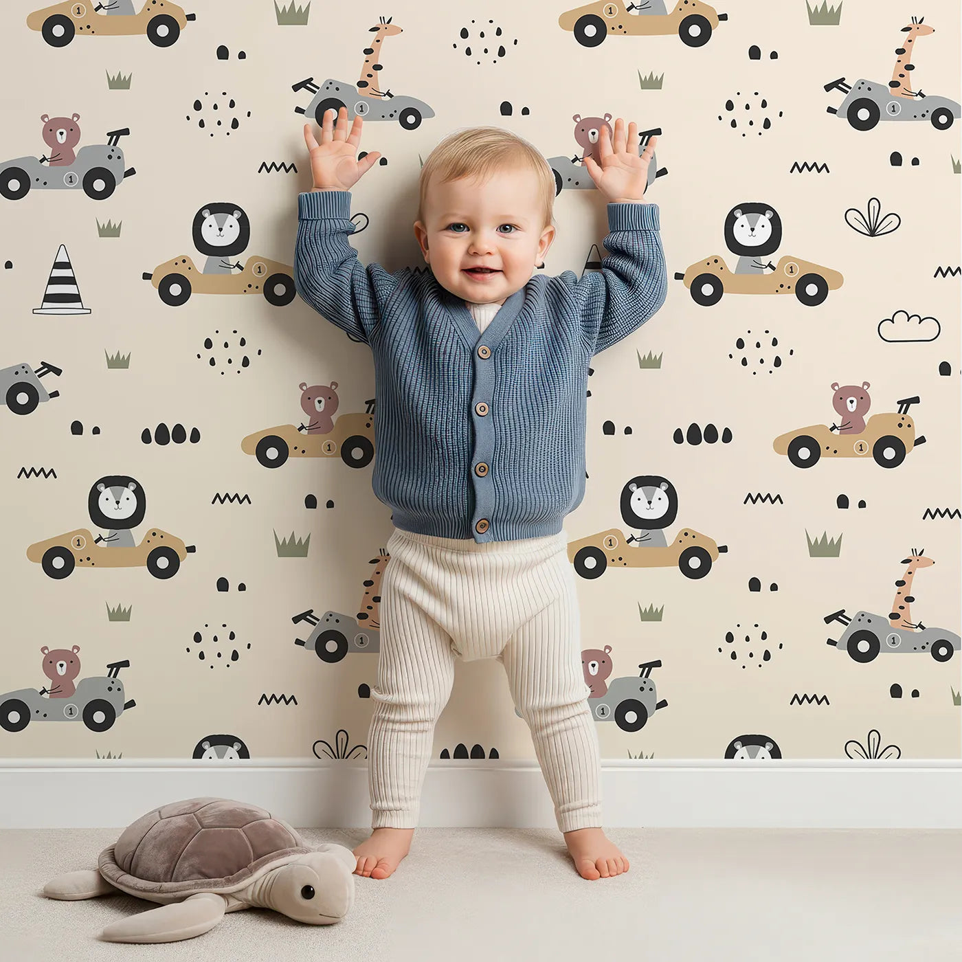 Lovely child standing in front of Whimsy Tots Safari Racers Parade Wallpaper in Sand Beige with lion, giraffe, bear, car, road, wheel in design.