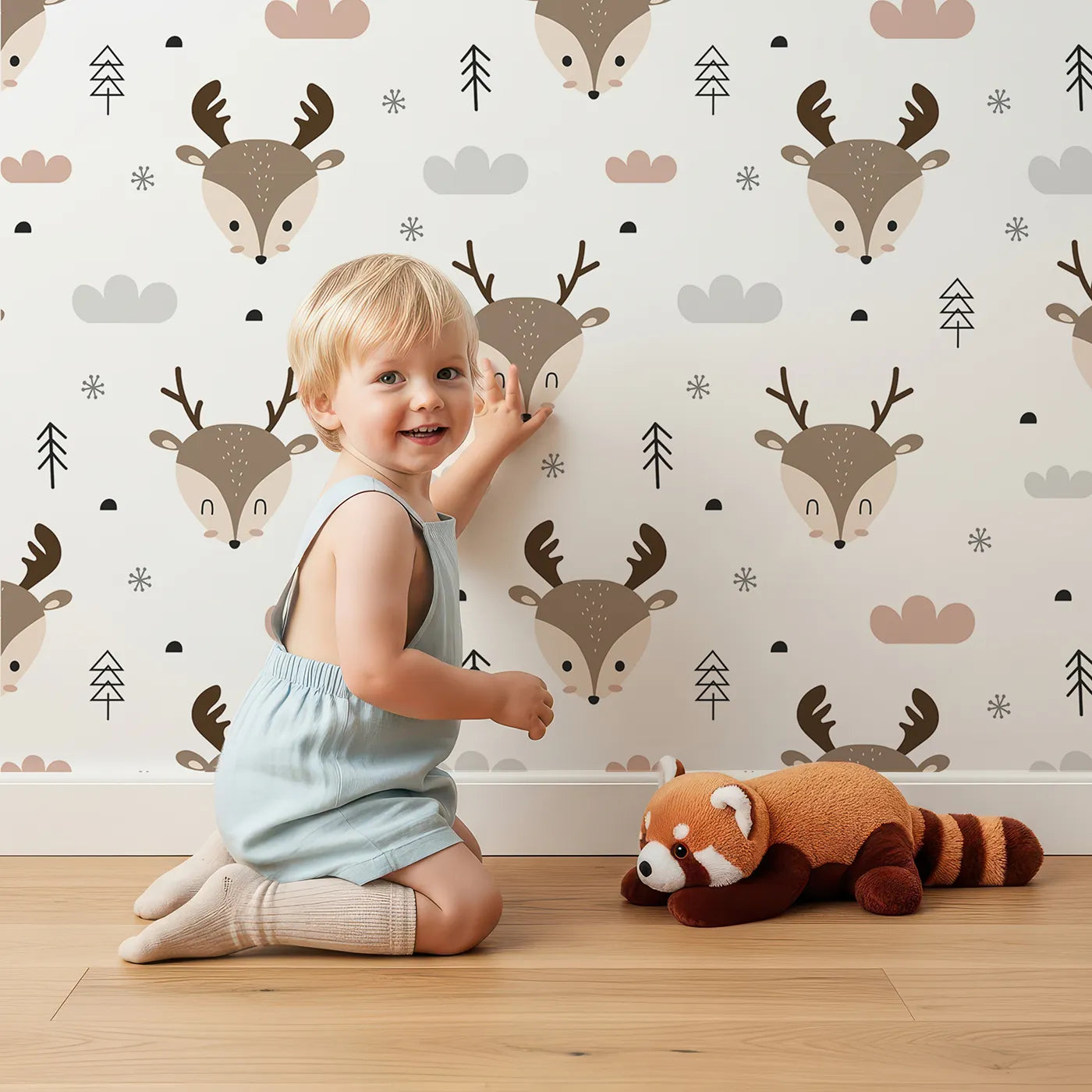 Lovely child standing in front of Whimsy Tots Woodland Deer Wallpaper in White with deer, cloud, tree, snowflake in design.