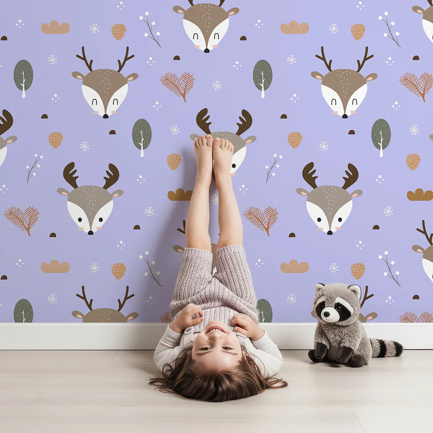 Lovely child standing in front of Whimsy Tots Forest Forager Deer Wallpaper in Lavender Mist with deer, pinecone, tree, snowflake, berry in design.