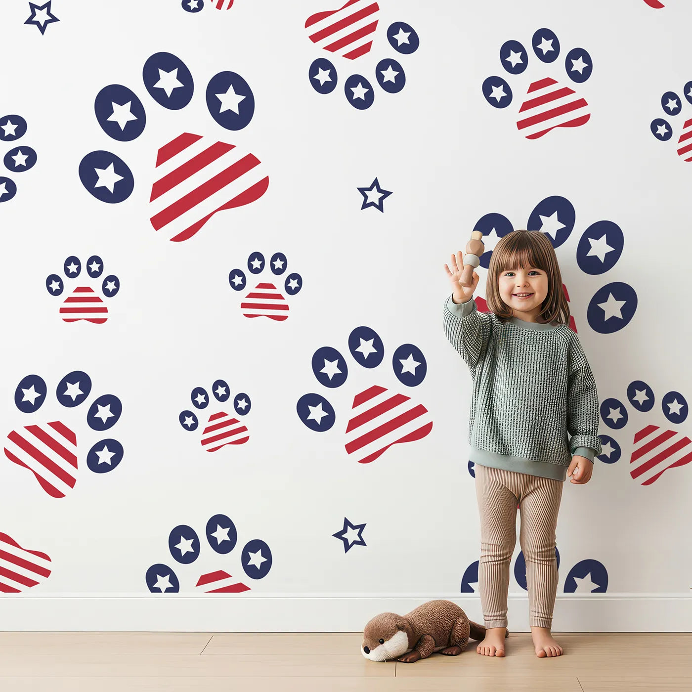 Lovely child standing in front of Whimsy Tots Patriotic Paws Parade Wallpaper with paw, star, stripe, print, patriotic in design.