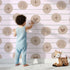 Lovely child standing in front of Whimsy Tots Boho Rhythm Doodle Wallpaper in Soft Blush Pink with rainbow, heart, star, stripe, doodle in design.