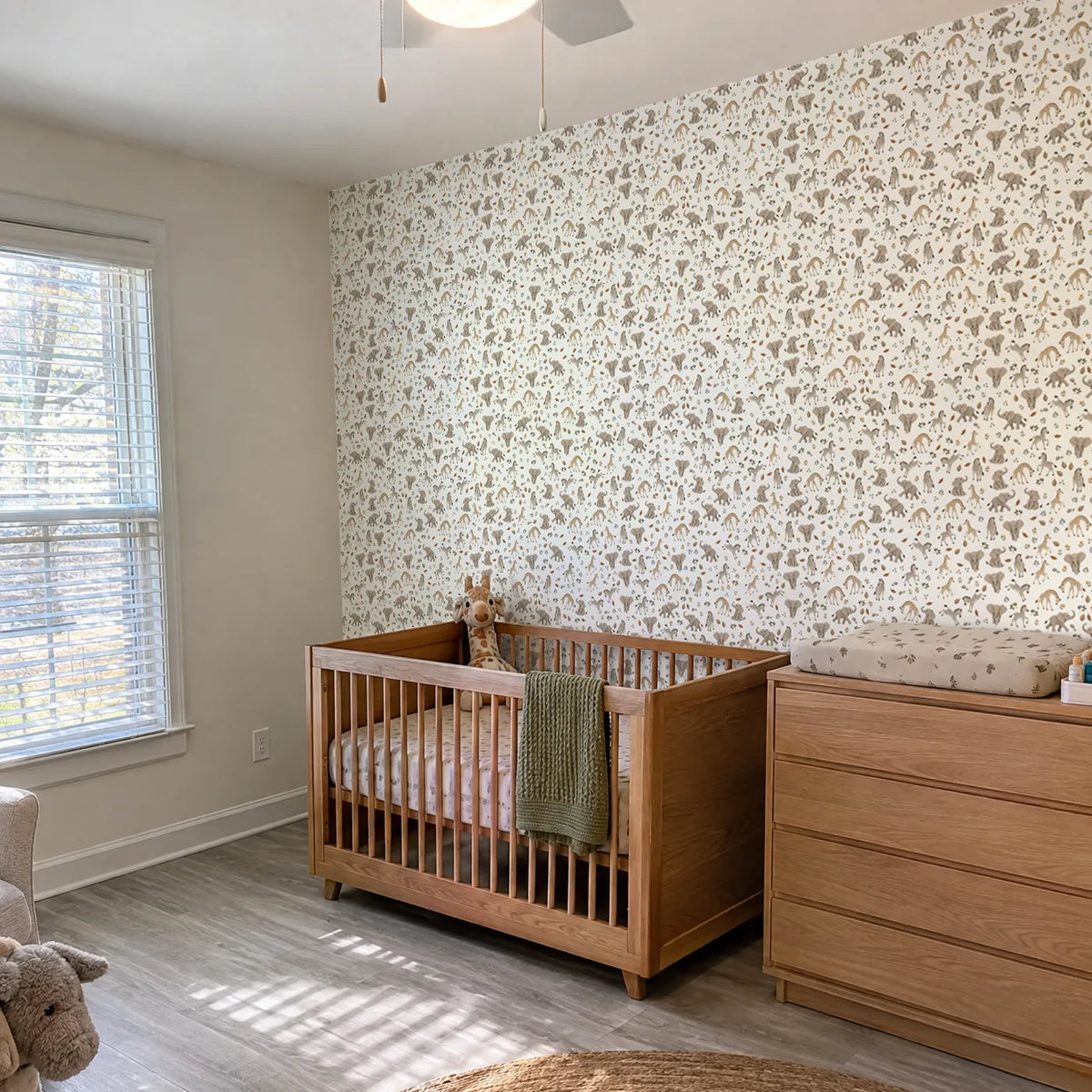 Gouache wallpaper of baby elephants, giraffes and zebras on warm cream, in a room photo, by Whimsy Tots